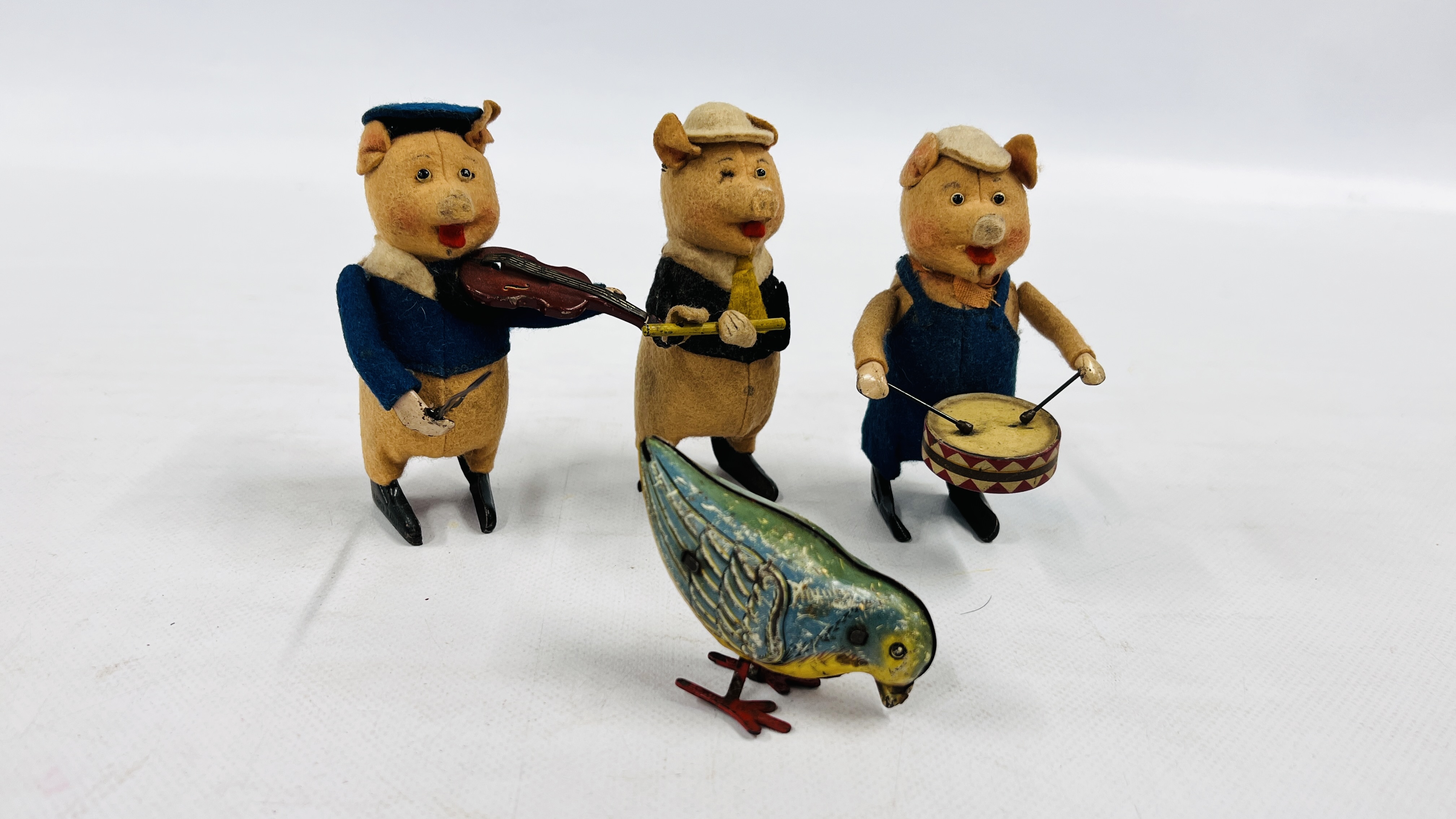 THREE PRE-WAR 1930s GERMAN SCHUCO CLOCKWORK FELT PIGS, PLAYING THE DRUMS, FLUTE AND FIDDLE,