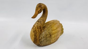 A CARVED WOODEN SWAN - HEIGHT 41CM X LENGTH 40CM.