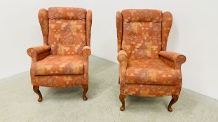 A PAIR OF SHERBORNE RED PATTERN UPHOLSTERED WINGED EASY CHAIRS.