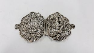 AN ELABORATE ANTIQUE SILVER FILGREE TWO PART BELT BUCKLE DEPICTING CHERUBS UPON A SWING,