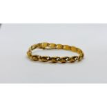 AN ELABORATE YELLOW METAL BRACELET WITH SAFETY CHAIN, THE CLASP MARKED WITH EASTERN SYMBOLS, L 16CM.
