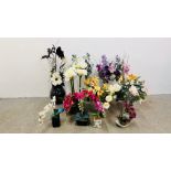 A GROUP OF 11 ARTIFICIAL FLOWER ARRANGEMENTS TO INCLUDE ORCHIDS, MANY IN GLASS VASES.
