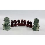 A PAIR OF CARVED HEADSTONE FOO DOGS, RED RESIN STUDY OF 7 BUDDHAS HOLDING VARIOUS OBJECTS.