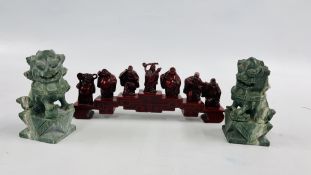 A PAIR OF CARVED HEADSTONE FOO DOGS, RED RESIN STUDY OF 7 BUDDHAS HOLDING VARIOUS OBJECTS.