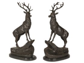 A PAIR OF BRONZE STAGS SIGNED T. MAIGNIERY, each standing on a rocky prominence and mounted on a