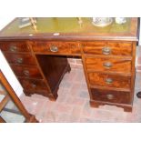 An antique pedestal desk with nine drawers to the