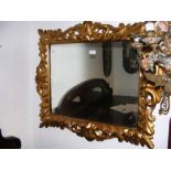 A decorative gilt wall mirror - 80cm x 90cm