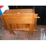 A teak foldout square garden table with two matchi