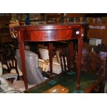 A mahogany half round fold over card table with re