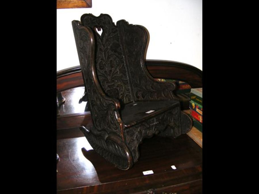 A small antique carved oak child's rocking chair