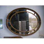 A 19th century decorative oval mirror in gilt surr