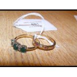 An emerald dress ring together with one other