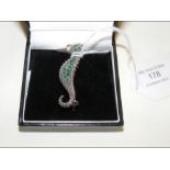 A silver seahorse brooch set with emeralds