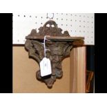 A cast iron Victorian wall shelf with mask design