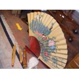 A collection of Oriental style parasols and fans