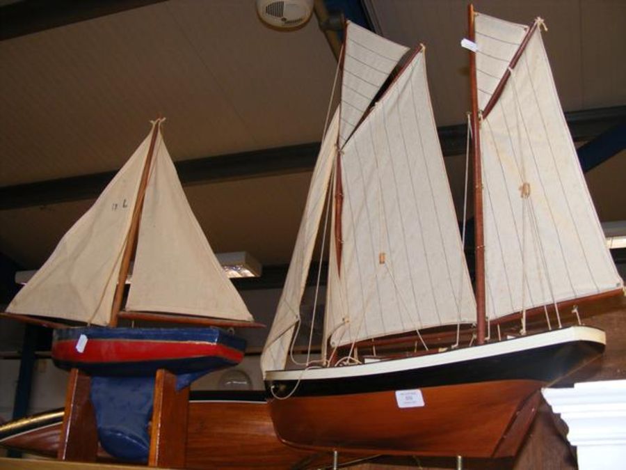 Two model yachts and a yacht hull