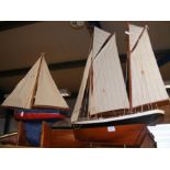 Two model yachts and a yacht hull