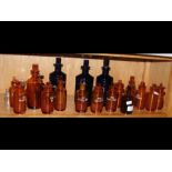 A collection of old amber and other glass apothecary bottles