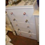 A painted chest of five drawers, fitted with decor