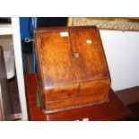 An oak stationery cabinet with fitted interior