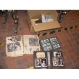 A medley of vintage postcards, cigarette cards and