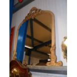 A large over mantel mirror in decorative scroll fr