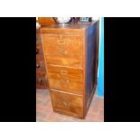 A vintage wooden filing cabinet of three drawers a