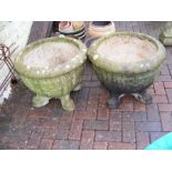 A pair of footed concrete urns