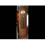 A 1930's oak longcase clock with brass cased weigh