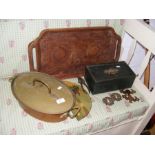 A carved wooden tray with a brass casserole dish,
