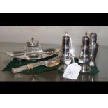 A silver inkwell on stand, three silver peppers, t