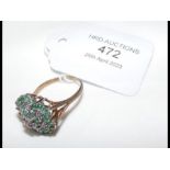 A diamond and emerald cluster ring in 9ct setting