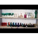 Two shelves of assorted coloured glass, including