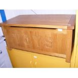 A contemporary light oak toy chest with safety sprung lid