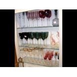 Three shelves of coloured glass, including two For