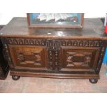 An antique oak coffer with panelled front - 135cm