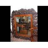 An extensively carved antique wall mirror - 128cm