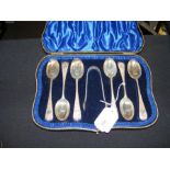 A set of six silver teaspoons with sugar tongs in