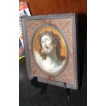 An oval religious painting in carved wooden frame