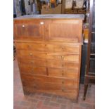 An oak multi draw chest with cupboard to the top -