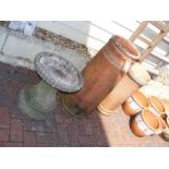 Two terracotta chimney pots and a stone bird bath