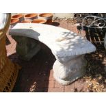 A curved stone garden bench
