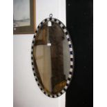 An antique Irish oval wall mirror with coloured gl