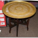 A Middle Eastern table with decorative brass top -