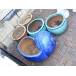 Five terracotta garden planters of varying shape a