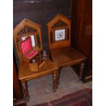 A pair of Victorian Gothic style hall chairs with