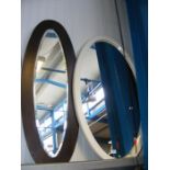 Two oval wall mirrors of varying size