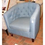 A tub armchair upholstered in light blue