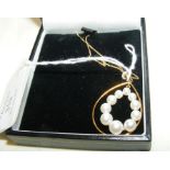 A pearl pendant in 9ct gold setting and chain