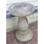 A circular birdbath on pedestal